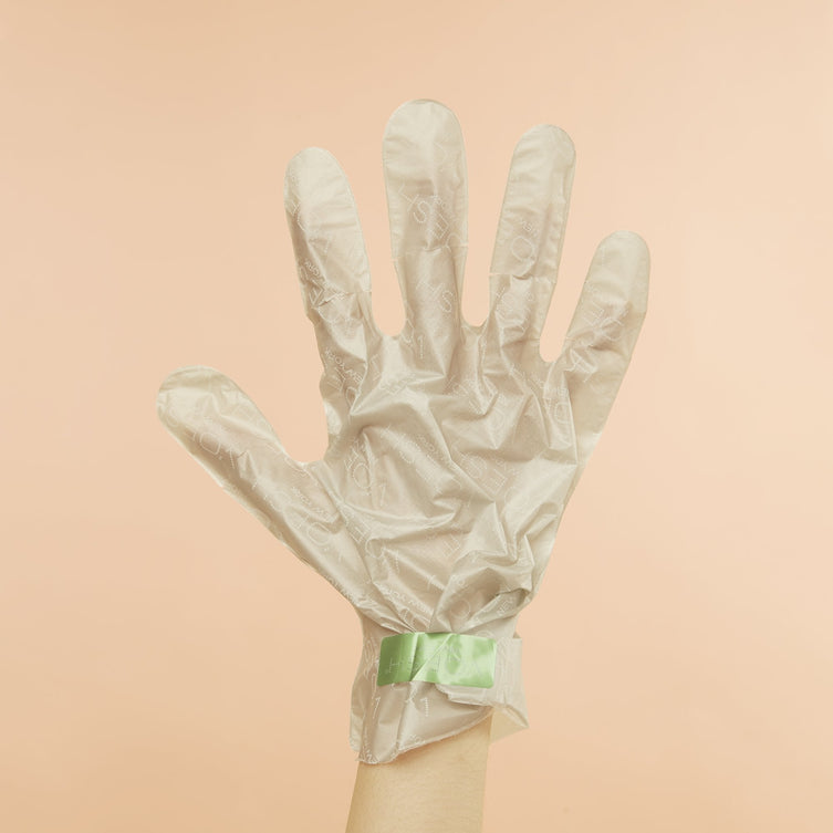 Woman's hand Wearing Collagen Gloves with Hemp Oil on pink background