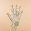 Woman's hand Wearing Collagen Gloves with Hemp Oil Tip removed on pink background